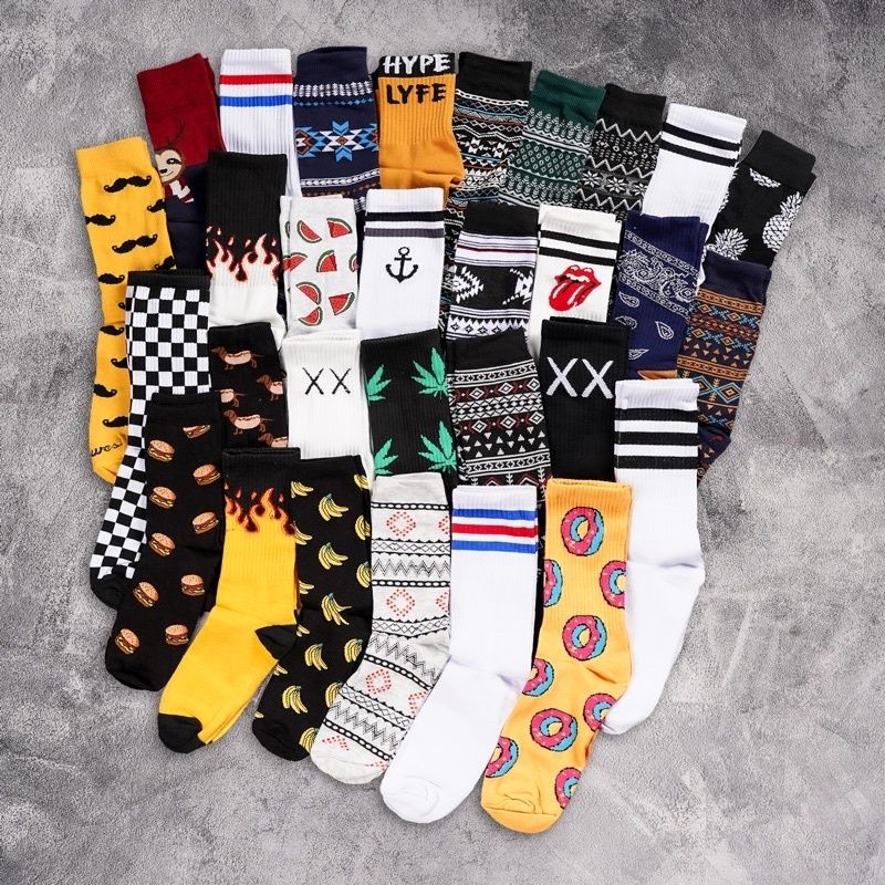 Various colorful socks with different patterns and designs arranged on a textured gray background.